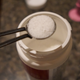Close-up of a spoonful of white Cafiza powder